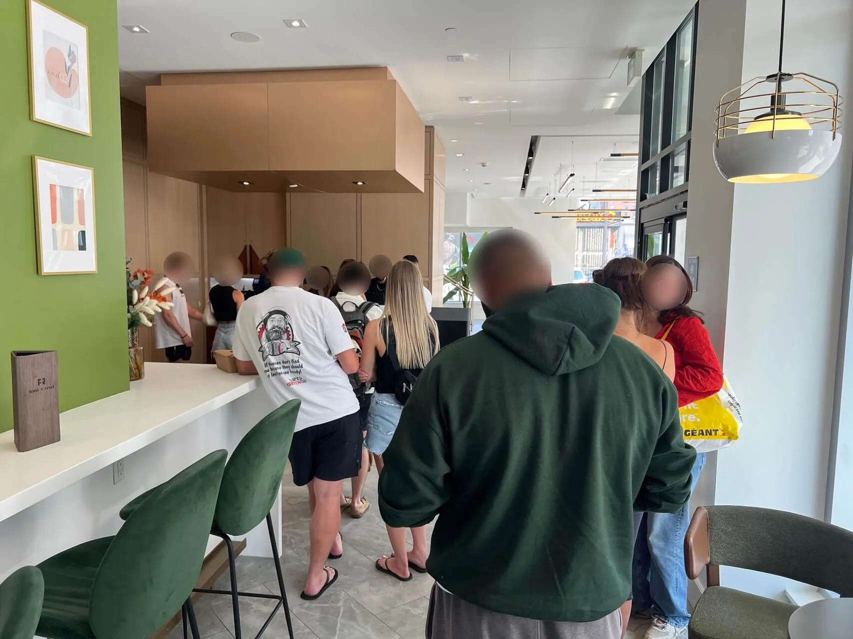 Busy check-in desk at Andaz Ottawa with queue of guests and green accent wall