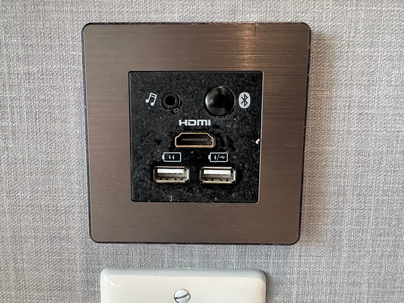 Multimedia wall outlet with HDMI, USB, and Bluetooth connections in bronze and black finish