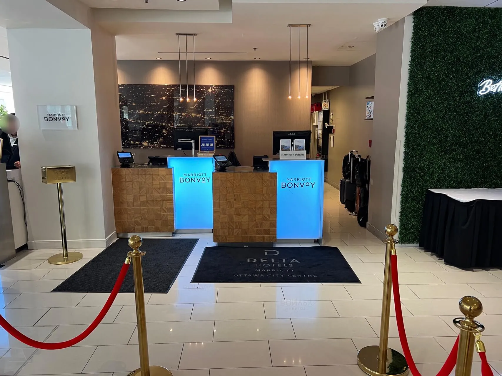 Delta lounge check-in desk with blue Marriott Bonvoy signage and cityscape backdrop in Ottawa