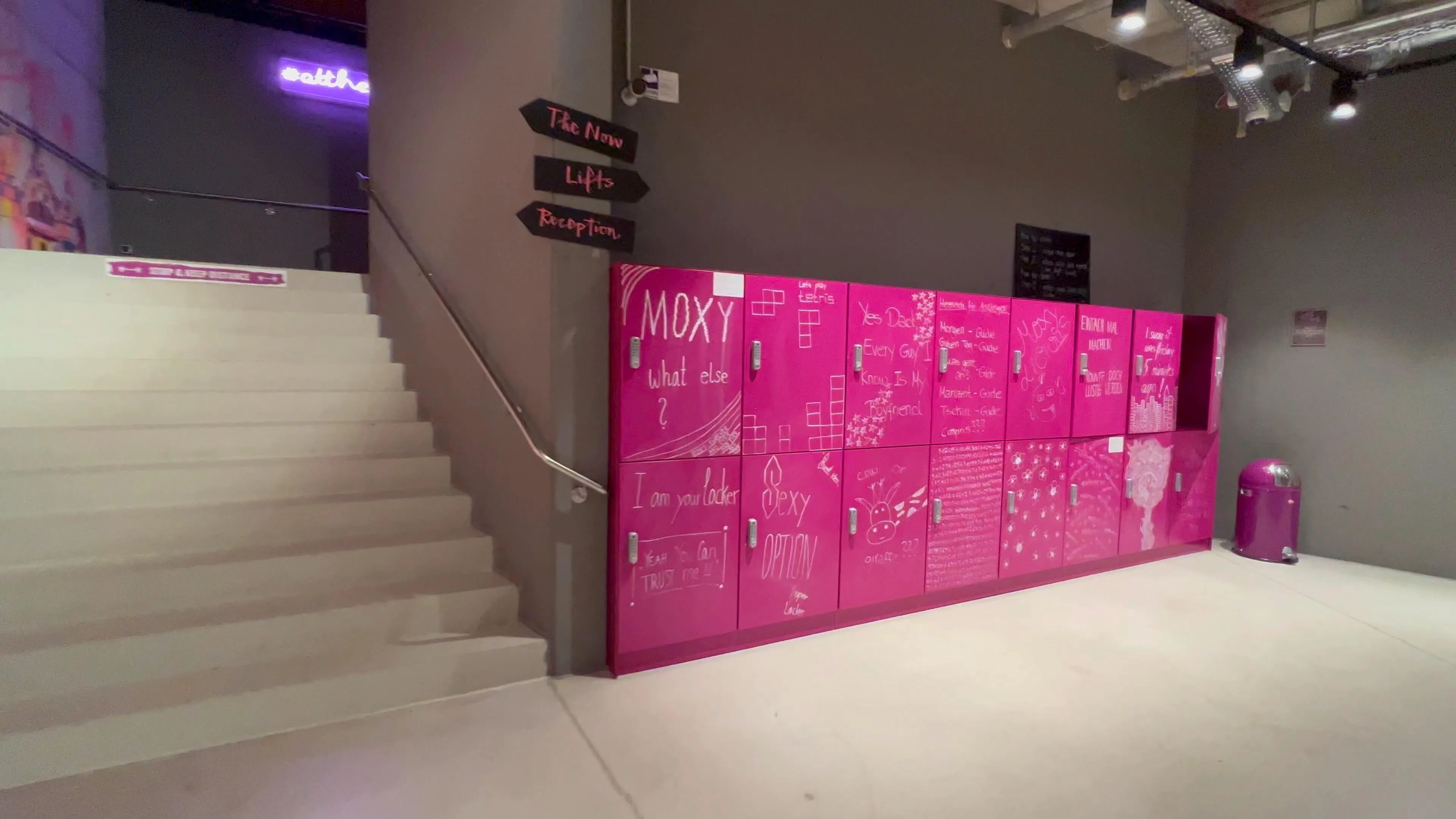 Moxy Frankfurt City Center lobby with bright pink lockers and white staircase