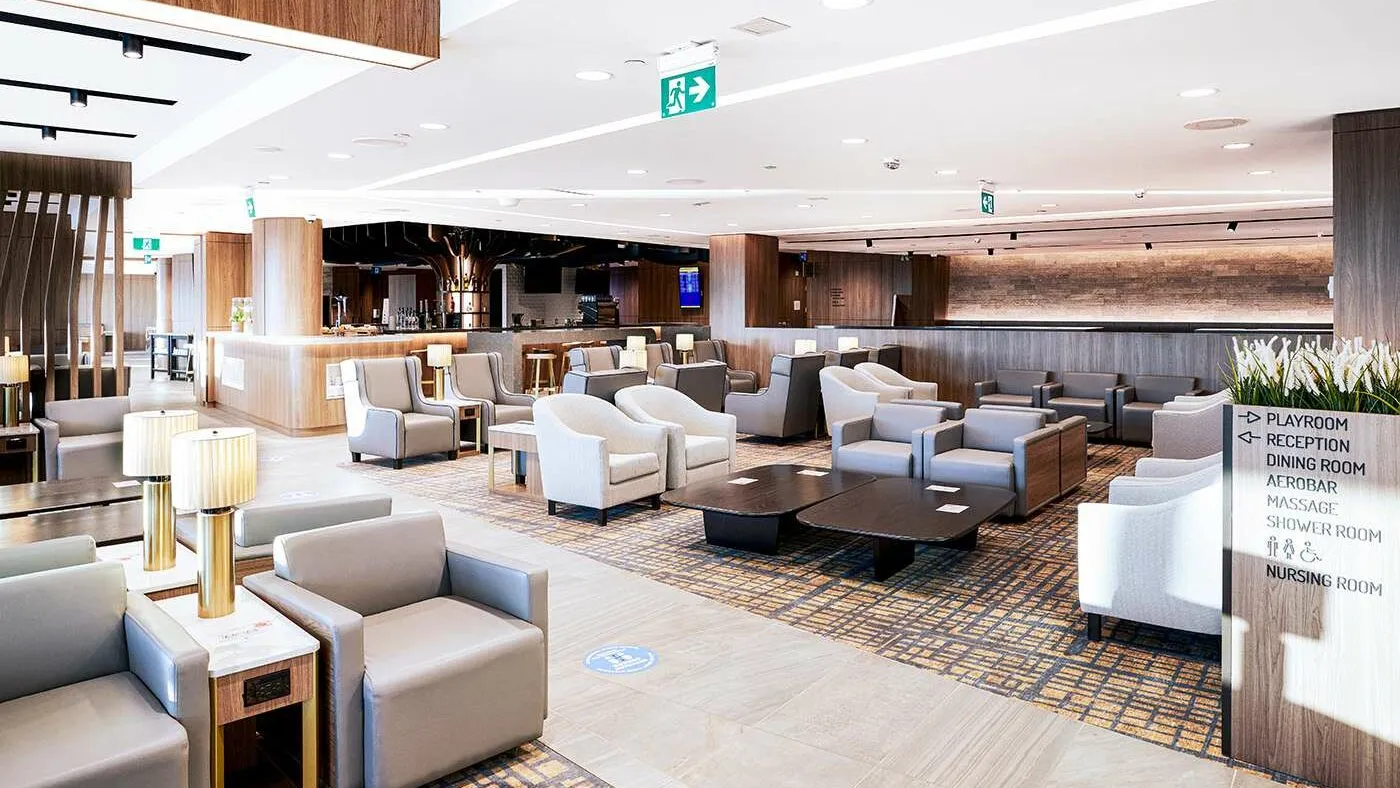 Plaza Premium Lounge seating area at Toronto with cream armchairs, wood accents, and modern interior