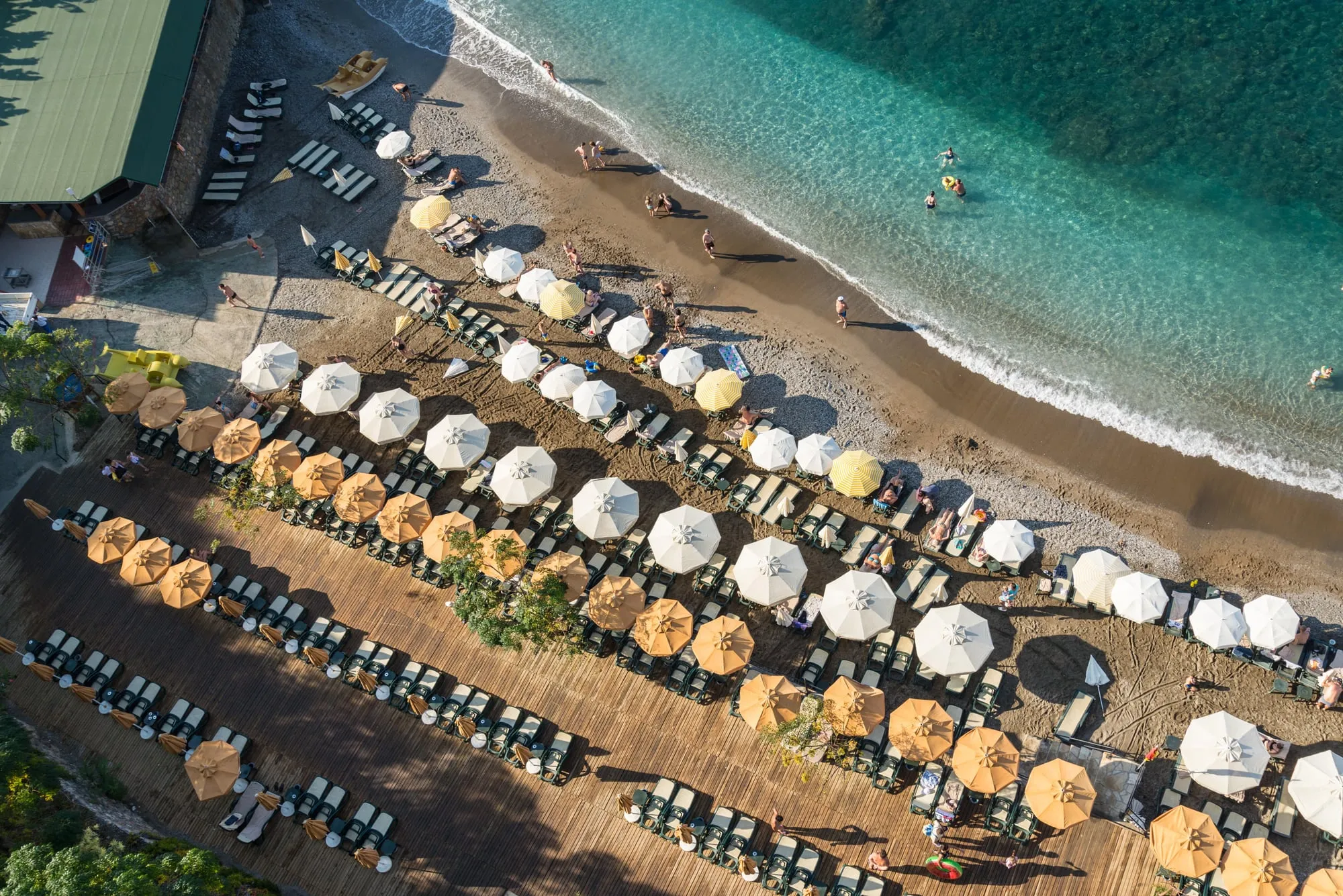 Rows of beach umbrellas and loungers along a turquoise sea in Alanya, Turkey