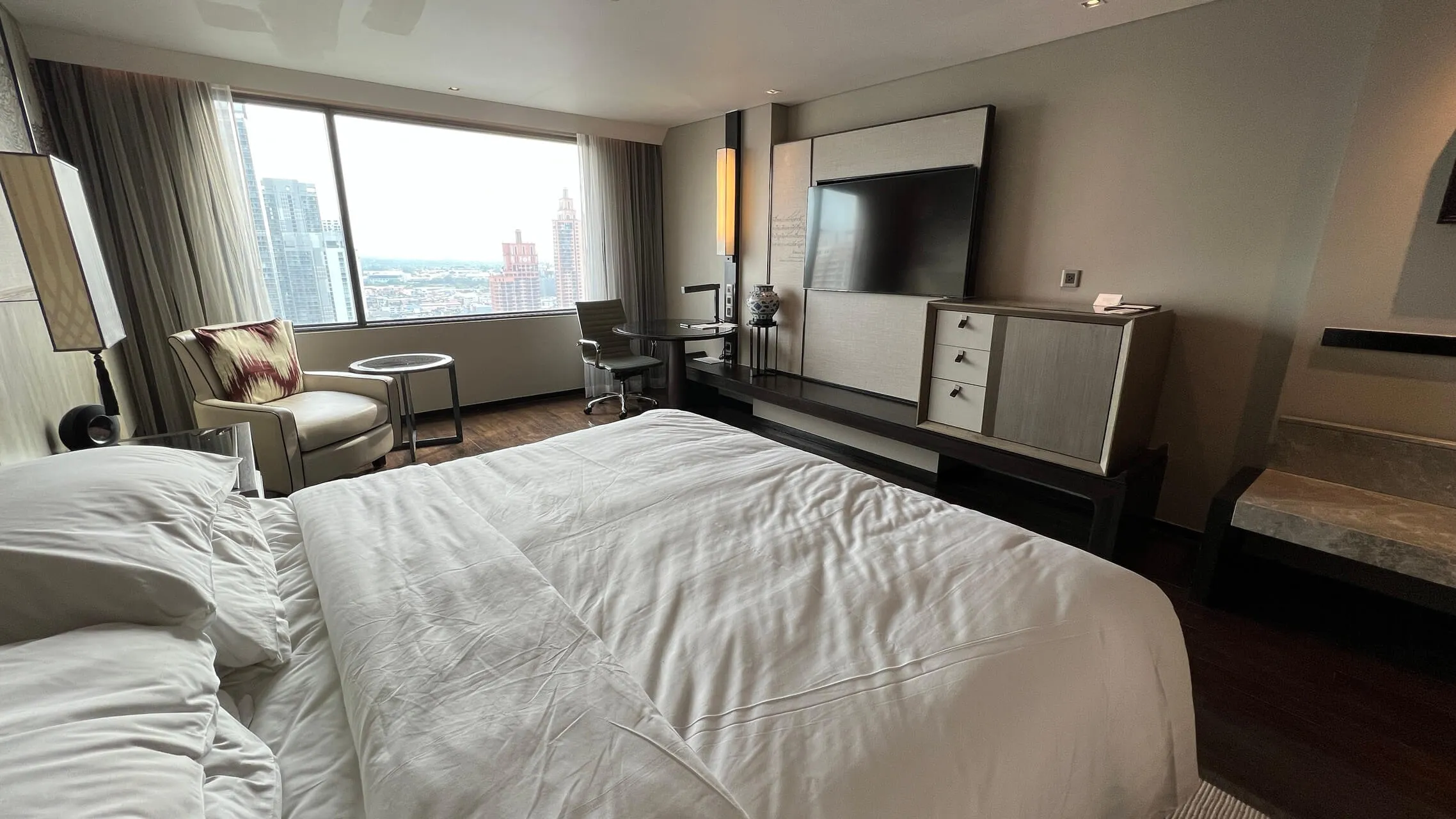 King bed with city view at Bangkok Marriott Marquis, modern room with TV, desk, and floor-to-ceiling windows