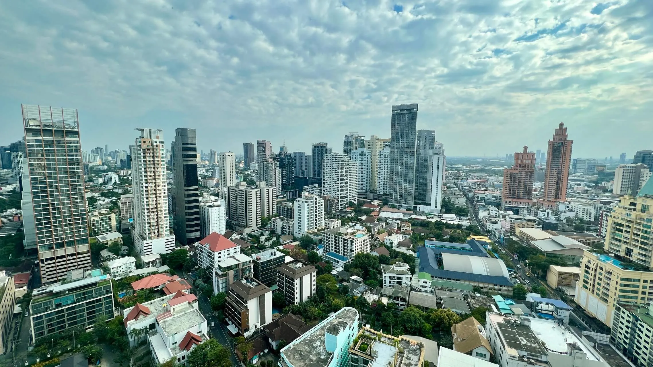 Bangkok skyline with high-rise hotels, office towers, and residential buildings under blue sky