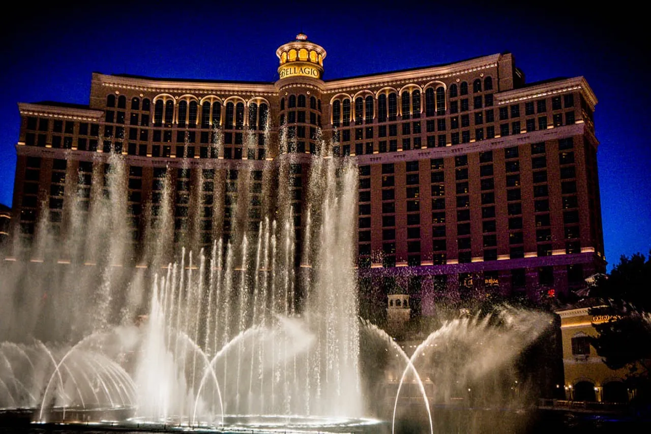Bellagio Hotel illuminated at night with elaborate fountain display in foreground, Las Vegas
