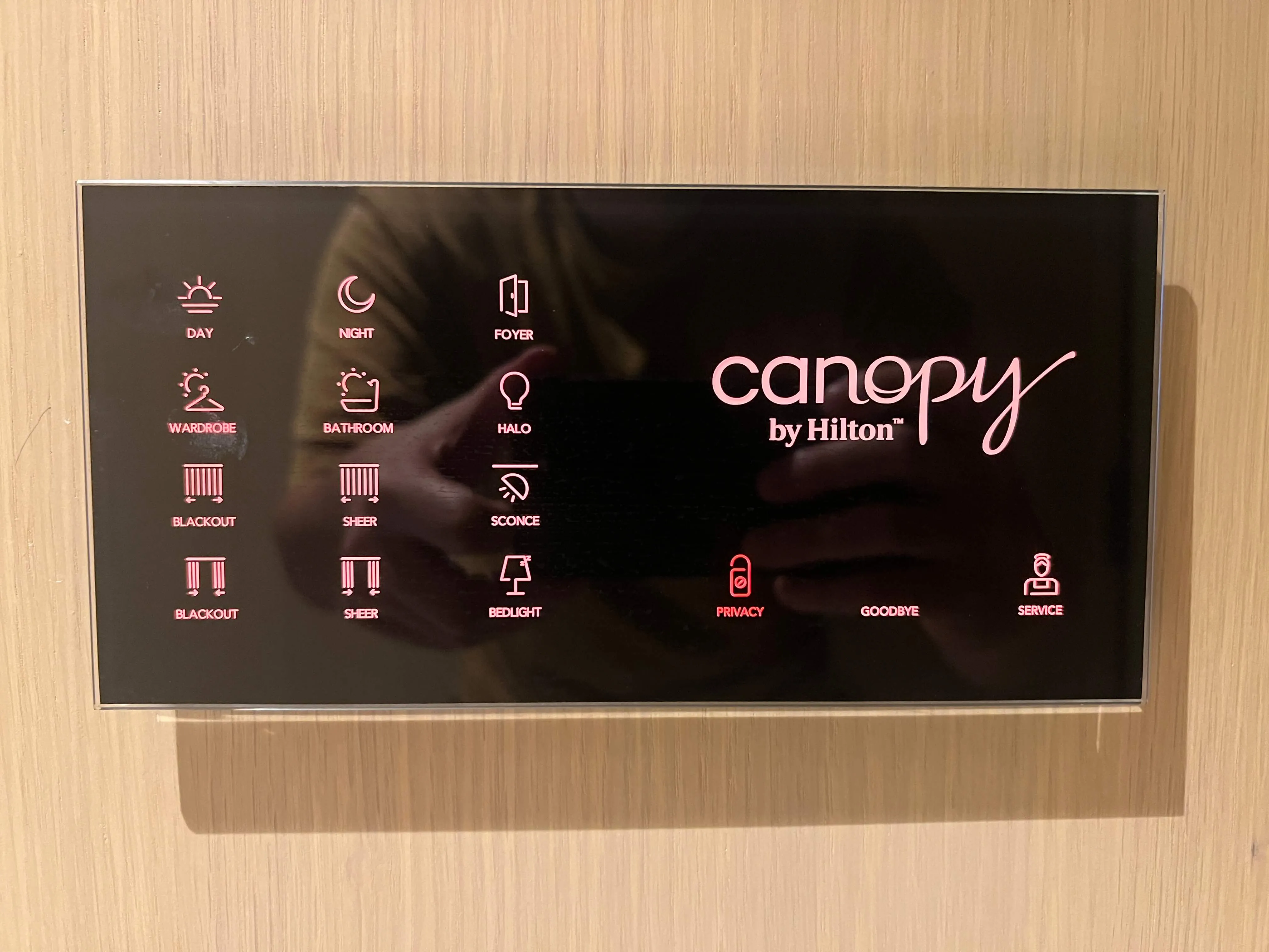 Canopy by Hilton hotel room control panel with day/night, foyer, wardrobe, bathroom, halo, blackout, sheer, sconce, bedlight, privacy, goodbye, and service icons on wooden wall