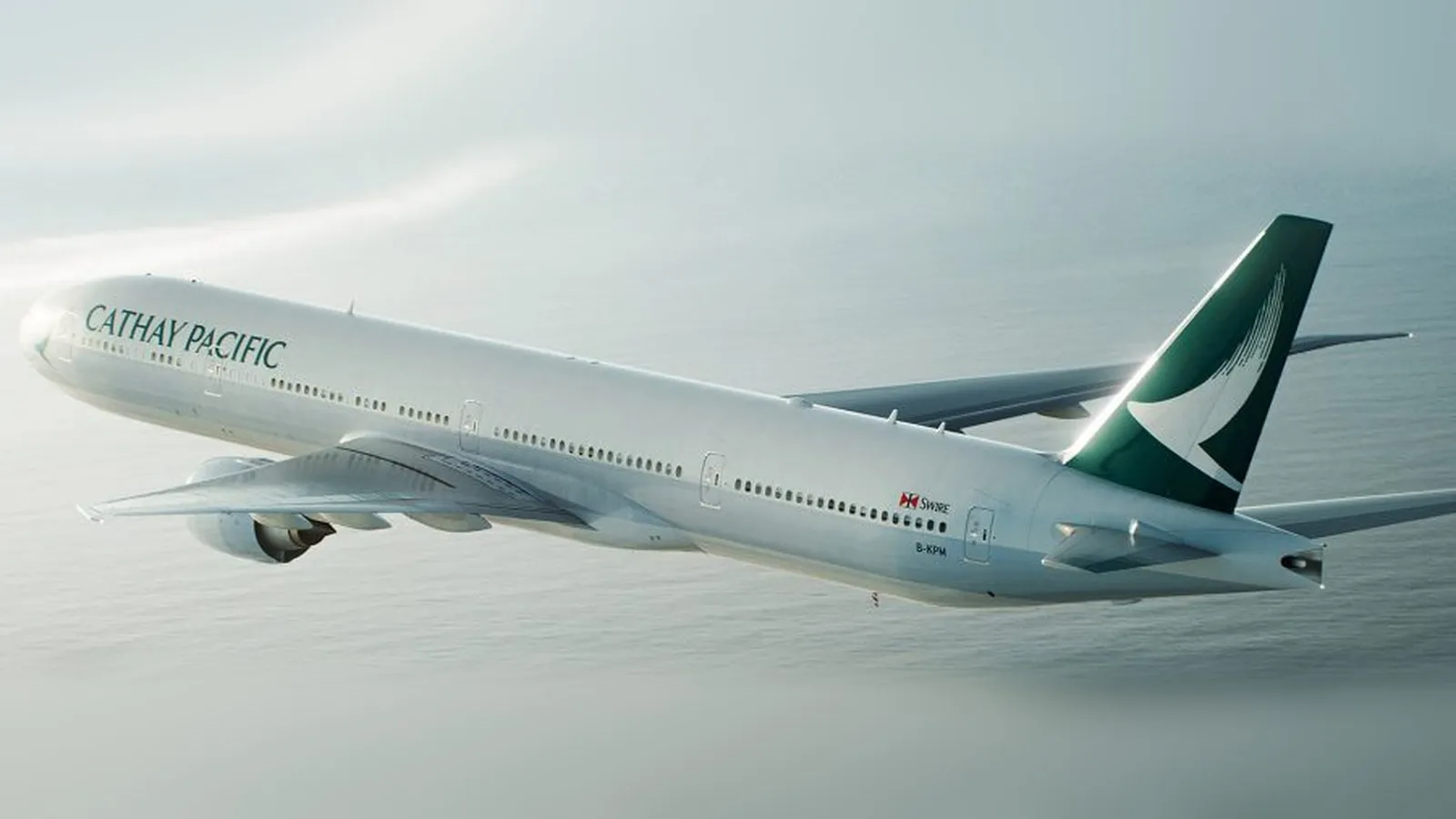 A Cathay Pacific Boeing 777 in flight over the sea