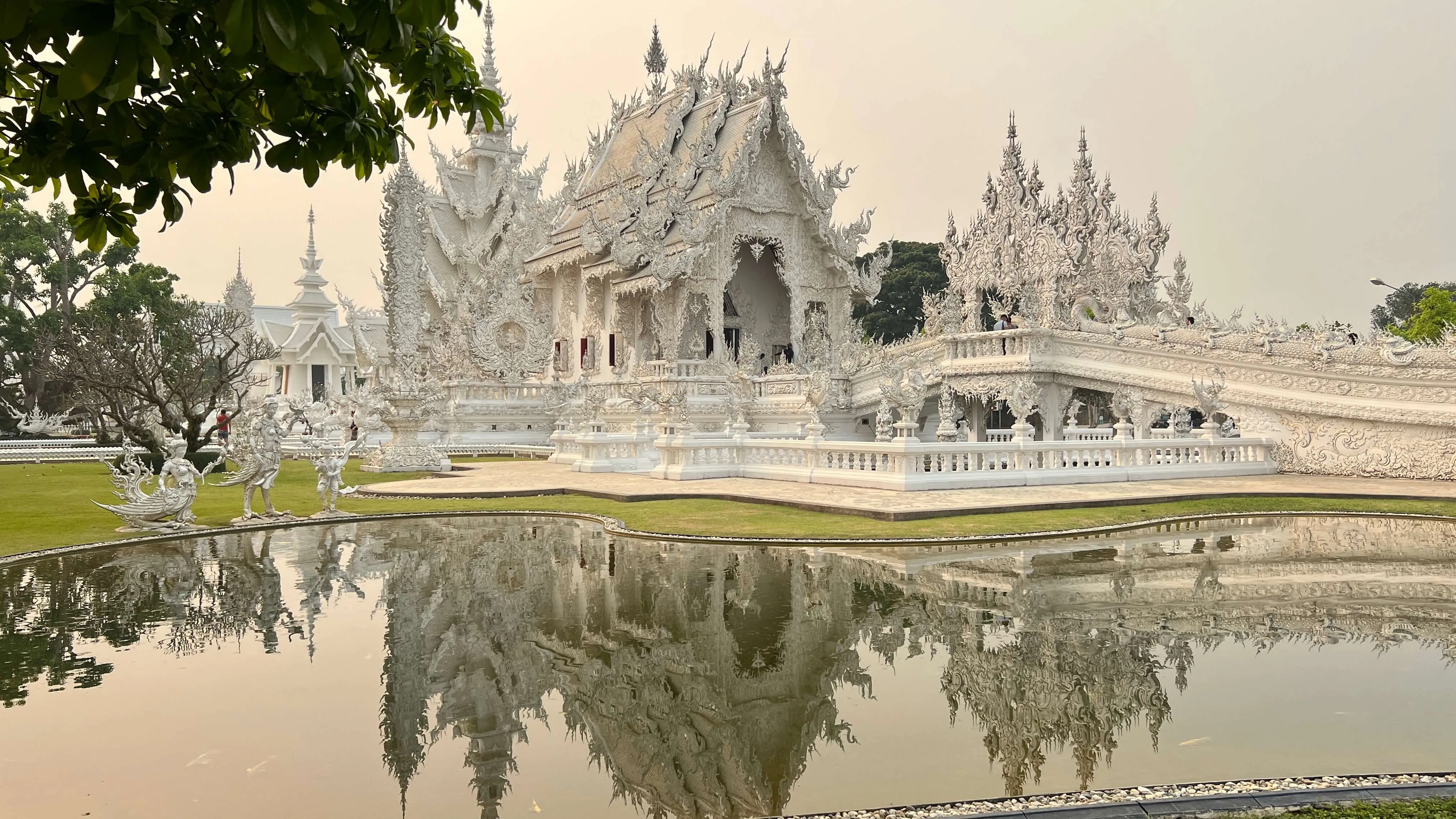 Wat Rong Khun white temple reflected in pond, Chiang Rai Thailand