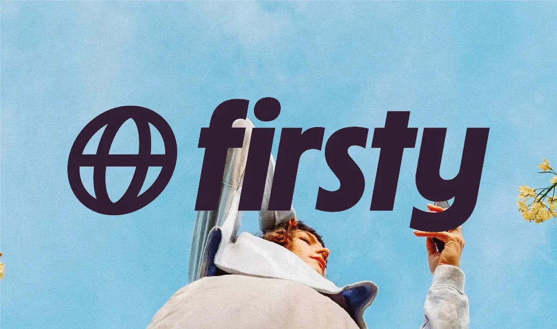 Person holding passport under Firsty travel brand sign against blue sky