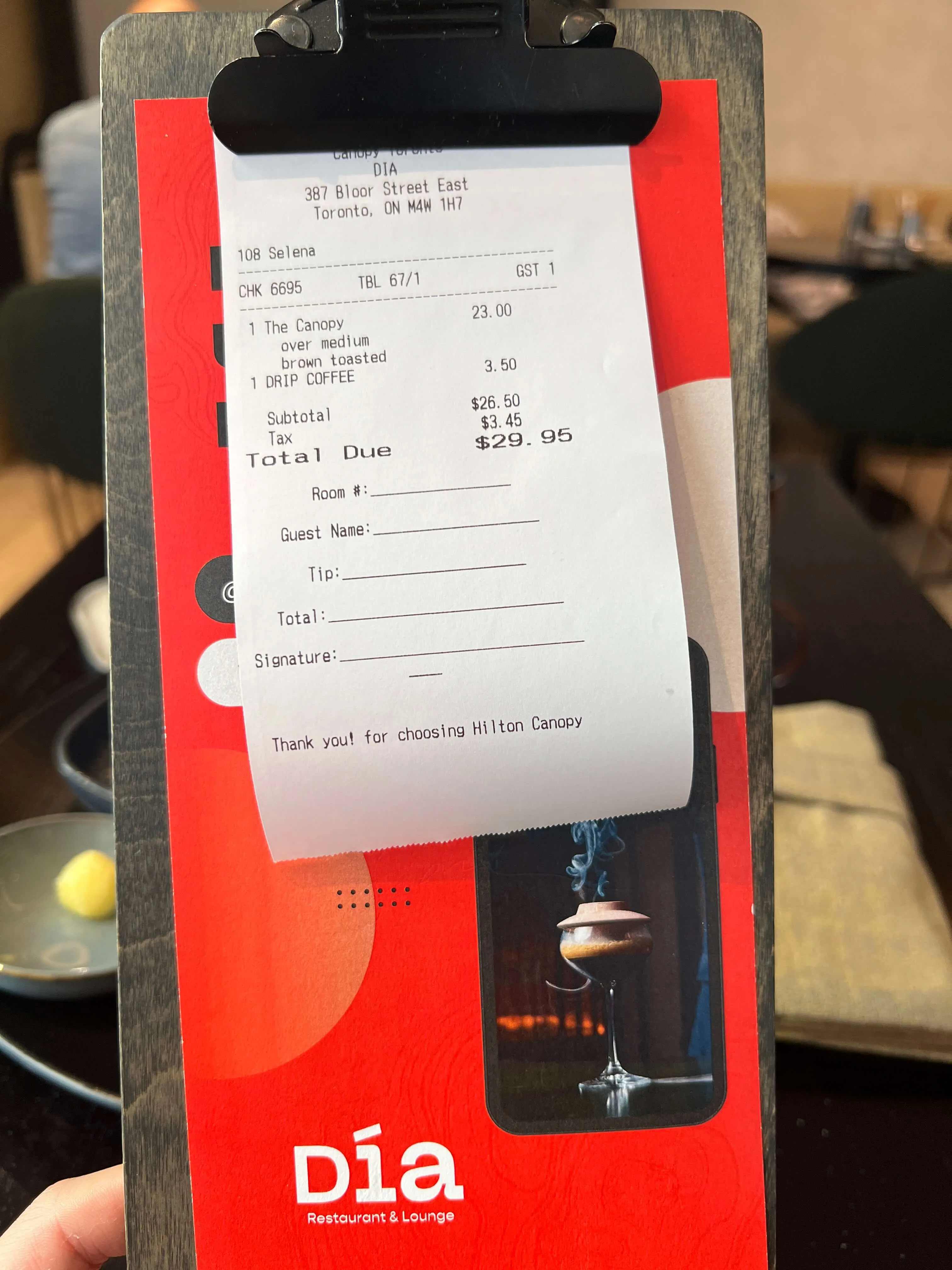 Hilton Canopy hotel receipt from DIA Restaurant & Lounge in Toronto on a branded red clipboard holder