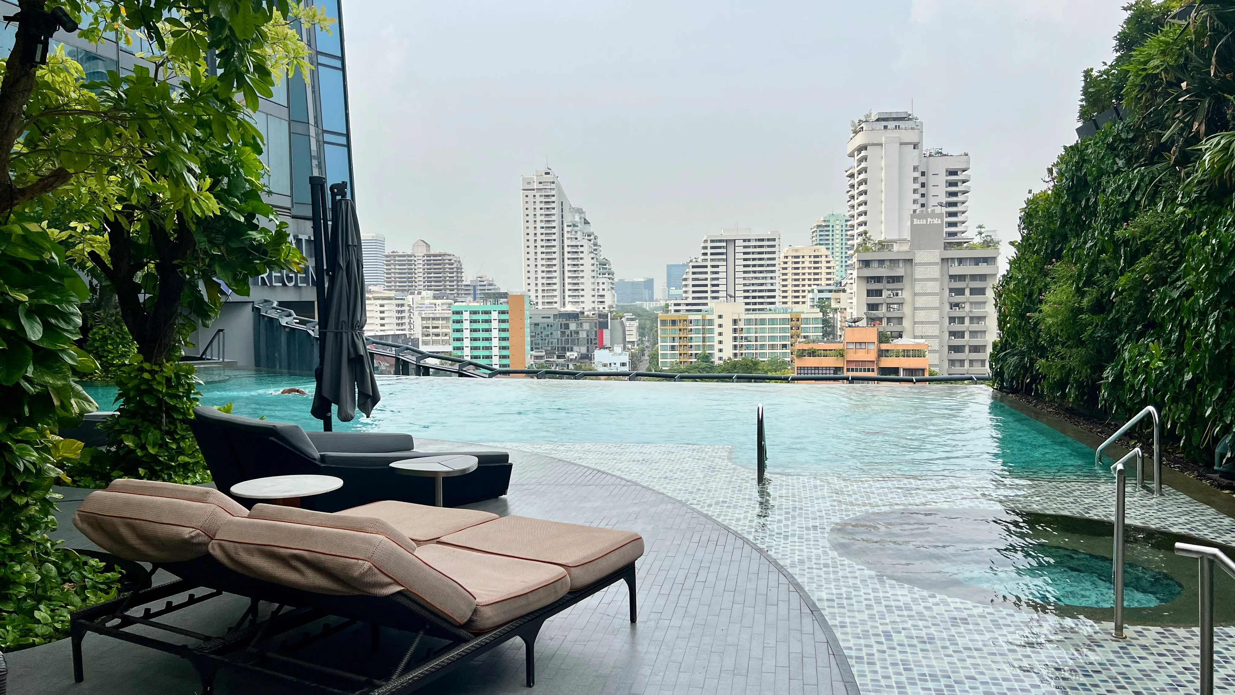 Hyatt Regency Bangkok pool with loungers and city skyline views across the Chao Phraya River
