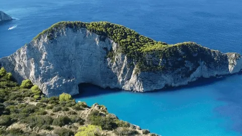 Navagio Beach with turquoise water, white limestone cliffs, and natural cave on Zakynthos island
