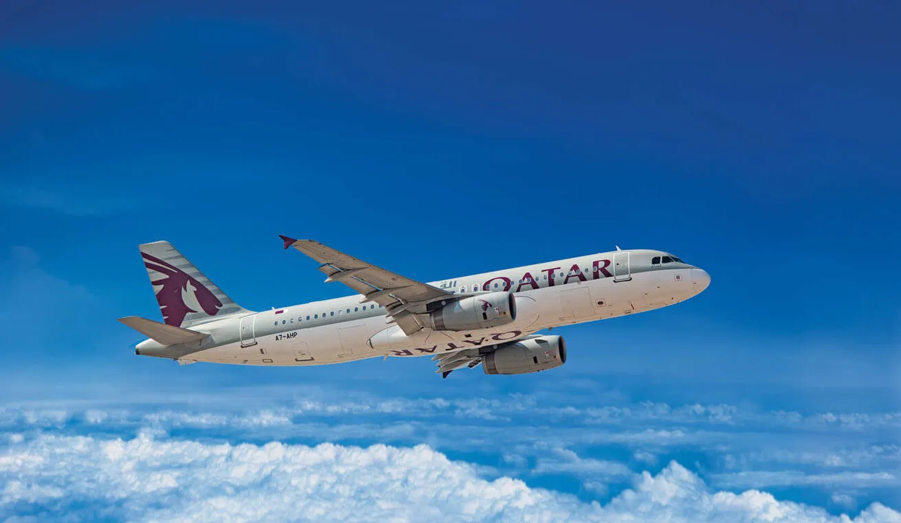 A Qatar Airways Airbus A320 in flight above the clouds
