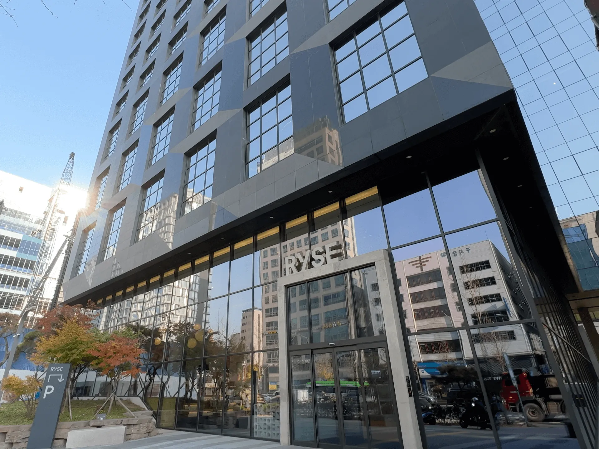 Modern glass and steel building entrance with NYSE signage reflected in large windows, Toronto street view