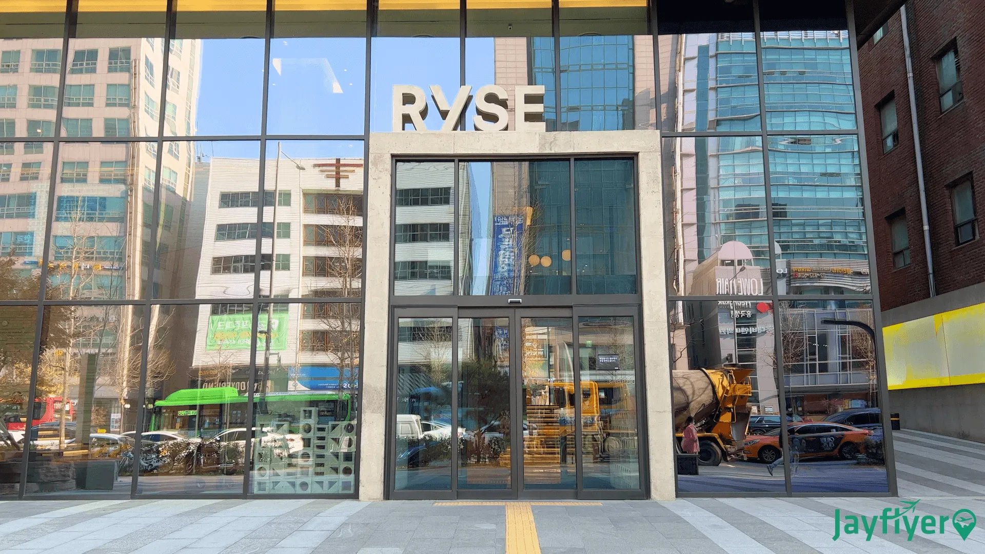 RYSE hotel entrance with glass storefront and signage on urban downtown street