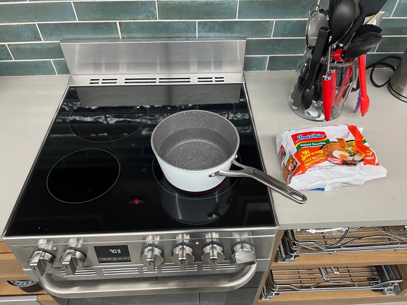 Induction cooktop with pot and instant noodles package in an Airbnb kitchen
